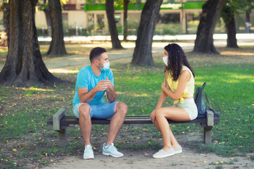 Young couple wearing masks having fun in the summer nature