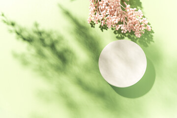 Empty white circle mockup podium for product presentation on a blooming spring flower background...