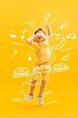 Creative design with drawn elements. Portrait of happy little boy, child posing over yellow background. Future dj, musician