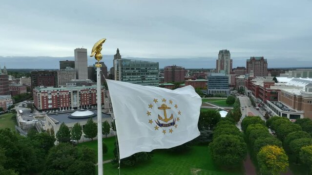 State flag of Rhode Island. RI USA is small state in United States. Aerial establishing shot of urban city.