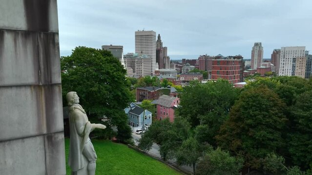 Providence Rhode Island skyline from Prospect Terrace Park. Statue of Roger Williams, founder of city. Rising aerial reveal shot of downtown cityscape.
