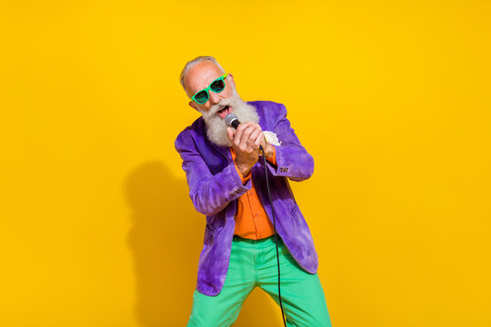 Photo Of Talented Retired Stylish Man Wear Retro Brigth Outfit Singing 80s 90s Favorite Hits Songs Isolated On Yellow Color Background