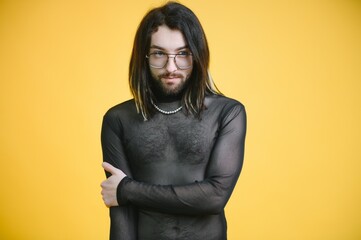 Young gay man is standing in the studio and posing for a camera.