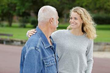 woman greeting older man in the park