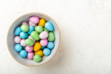 Heap of colorful chocolate eggs in a ceramic bowl
