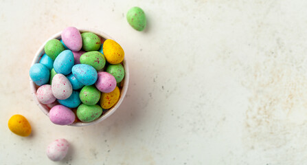 Overhead shot of several colorful glazed chocolate eggs with copy space