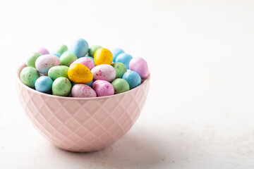 Heap of colorful glazed chocolate eggs in a bowl