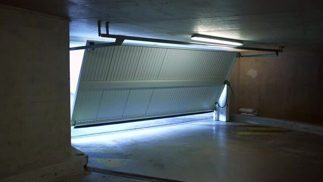 Opening automatic underground garage door. Mother leaving home with child riding bicycle. Parent going out for weekend activity or commute