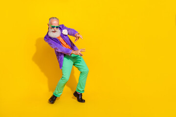 Fototapeta na wymiar Full length photo of cheerful attractive man wear purple velvet jacket having fun discotheque empty space isolated yellow color background