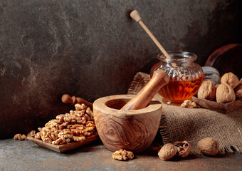 Walnuts and honey on a kitchen table.