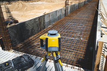 Nivellieren auf einer Baustelle mit einem Laser-Nivelliergerät.