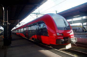 Naklejka premium Red electric train near the platform. Close-up.