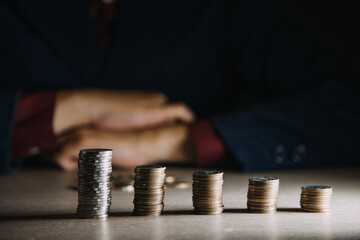 businesswoman hand puting coins in glass for saving money. concept finance and accounting