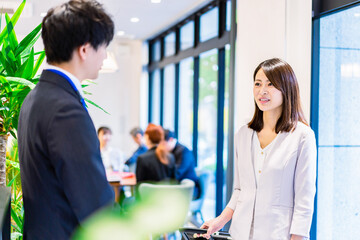 Fototapeta premium フロントでホテルのチェックインをする若いビジネスウーマン