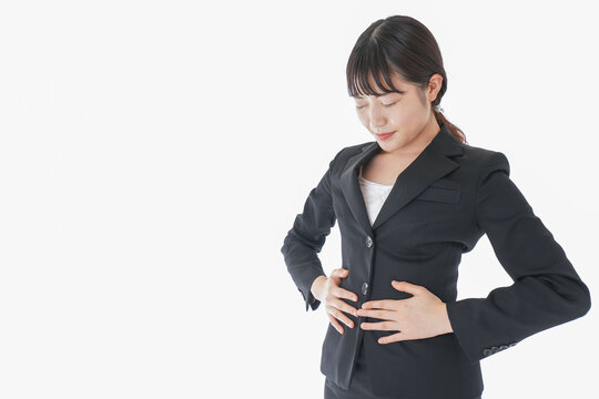 腹痛に苦しむ若いビジネスウーマン
