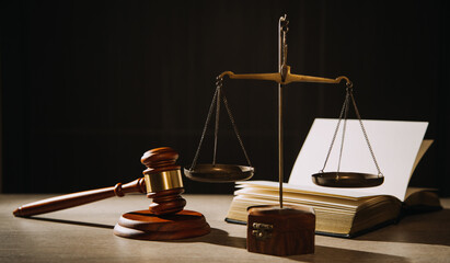 Justice and law concept.Male judge in a courtroom with the gavel, working with, computer and docking keyboard, eyeglasses, on table in morning light