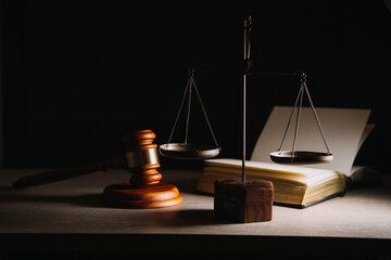 Justice and law concept.Male judge in a courtroom with the gavel, working with, computer and docking keyboard, eyeglasses, on table in morning light