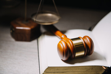 Justice and law concept.Male judge in a courtroom with the gavel, working with, computer and docking keyboard, eyeglasses, on table in morning light