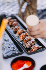 Man eating sushi set with chopsticks on restaurant