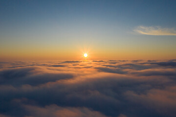 the sun rises above the clouds