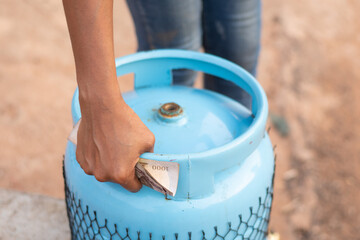 black lady holding a gas cylinder and cash