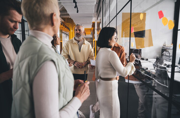 Group of entrepreneurs discussing project in contemporary workplace