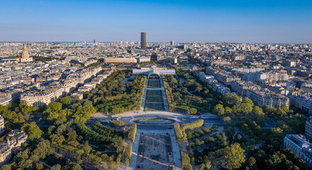 Champ de Mars park with long shadows during sunset with Tour Montpanasse and Paris rooftops.
