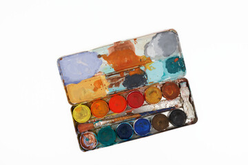 vintage paintbox with old colors inside rusty metal box isolated on white background