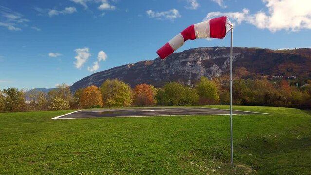 Windsock moving in the wind next to an helipad in 4k