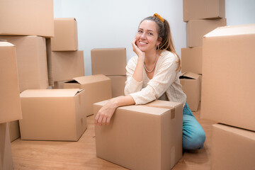 Fototapeta premium Beautiful girl with cardboard boxes unpacking in new home. High quality photo