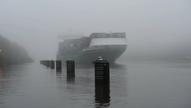 Containerschiff an den Dalben bei Nebel im Nord-Ostsee-Kanal