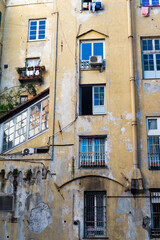 Fototapeta na wymiar Ruined facade of an old building in the popular neighborhood of Genova, Italy.