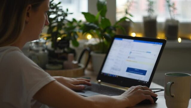 Girl sit down at home office desk table to work remotely, Female business woman scroll web page on using laptop notebook typing keyboard working online. technology distant concept, close up, in winter