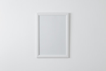 Empty picture frame mockup on clean wall. Blank surface for copy or art presentation. White wooden frame