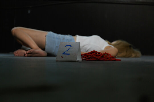 Blurred, the female victim's body was strangled with a killing rope to lie flat on the floor of an abandoned building.