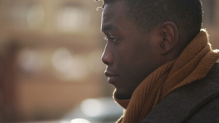 Melancholical black african man thinking in contemplation while walking outside in city