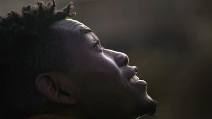 Meditative African man closing and opening eyes looking at sky smiling with FAITH and BELIEF