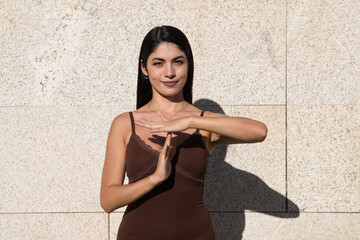 Portrait of woman, young, happy, smiling woman showing free time gesture with hands isolated on grey wall background. Positive human emotion facial expressions, body language reaction feeling.