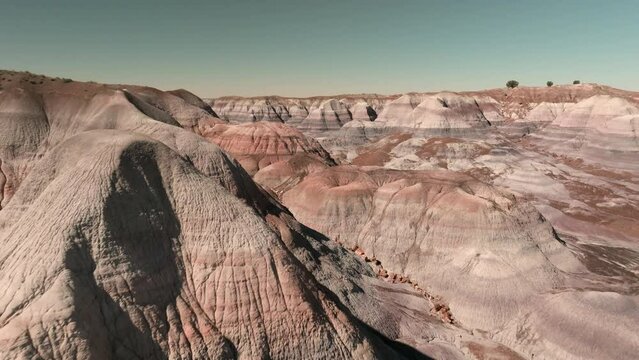 Aerial reverse dolly through colorful hills of Petrified Forest National Park.