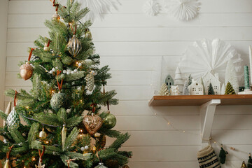 Christmas tree with vintage baubles and little christmas village decoration. Modern christmas tree...