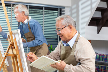 senior painting in art class with friends from her care home for the aged copying a painting with...