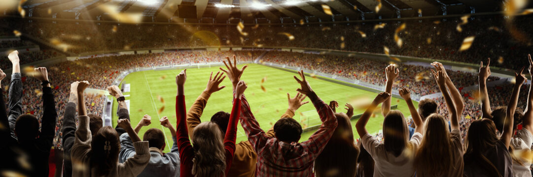 Victory. Back view of football soccer fans cheering their team with colorful scarfs at crowded stadium at evening time. Concept of sport, cup, world, team, event, competition