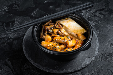 Korean street food Tteokbokki, Topokki fried rice cake stick in spicy sauce. Black background. Top...
