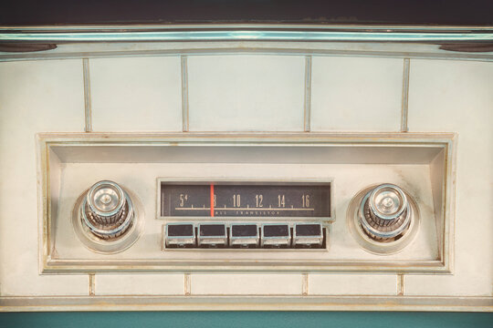Old car radio inside a green classic American car with chrome dashboard