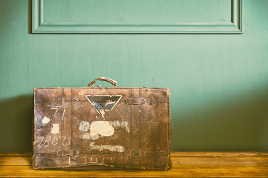 Retro styled image of a weathered vintage travel suitcase in an old living room
