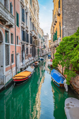 Fototapeta na wymiar Moored boats on small canal in city of Venice, Italy.