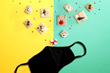 Christmas gift boxes with a cloth black face mask - flat lay