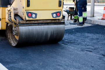 Naklejka premium The road roller machine works with fresh and hot asphalt.
