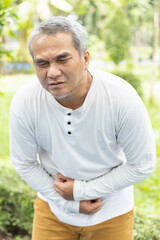 Naklejka na ściany i meble old senior asian man being sick with stomachache concept image for abdominal pain, diarrhea, constipation, food poisoning, gastritis, acid reflux, ulcer, stomach cancer, colon cancer