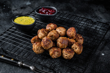 Swedish meatballs with lingonberries and gravy sauce. Black background. Top view